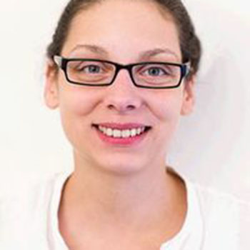 Person with glasses smiling against a white background.