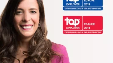 Femme souriante avec prix Top Employer 2018 pour l'Europe et la France en arrière-plan.