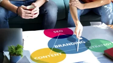 Deux personnes discutent d'une stratégie de marque avec des diagrammes colorés.