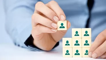 Main empilant des cubes avec des silhouettes de personnes