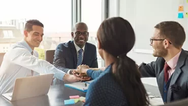 Quatre personnes se réunissent autour d'une table de réunion.