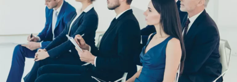 Groupe de personnes assises dans une salle de conférence.