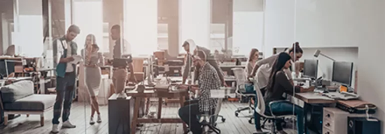 Un bureau moderne avec plusieurs personnes travaillant à leurs ordinateurs.