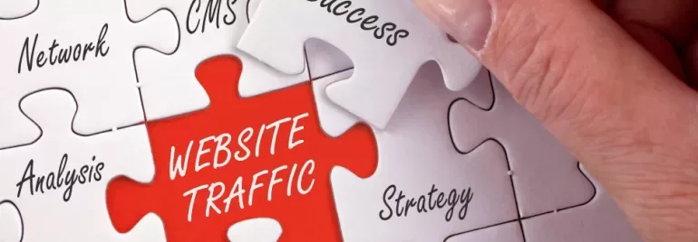 Main rouge disant 'trafic de site' en puzzle, main ajustant une pièce.
