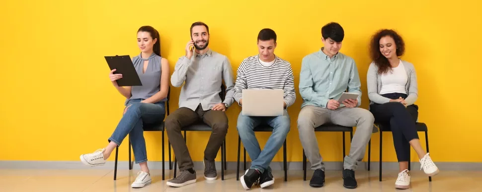 Groupe de personnes assises, utilisant divers appareils.